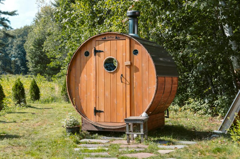 A timber barrel sauna in a garden
