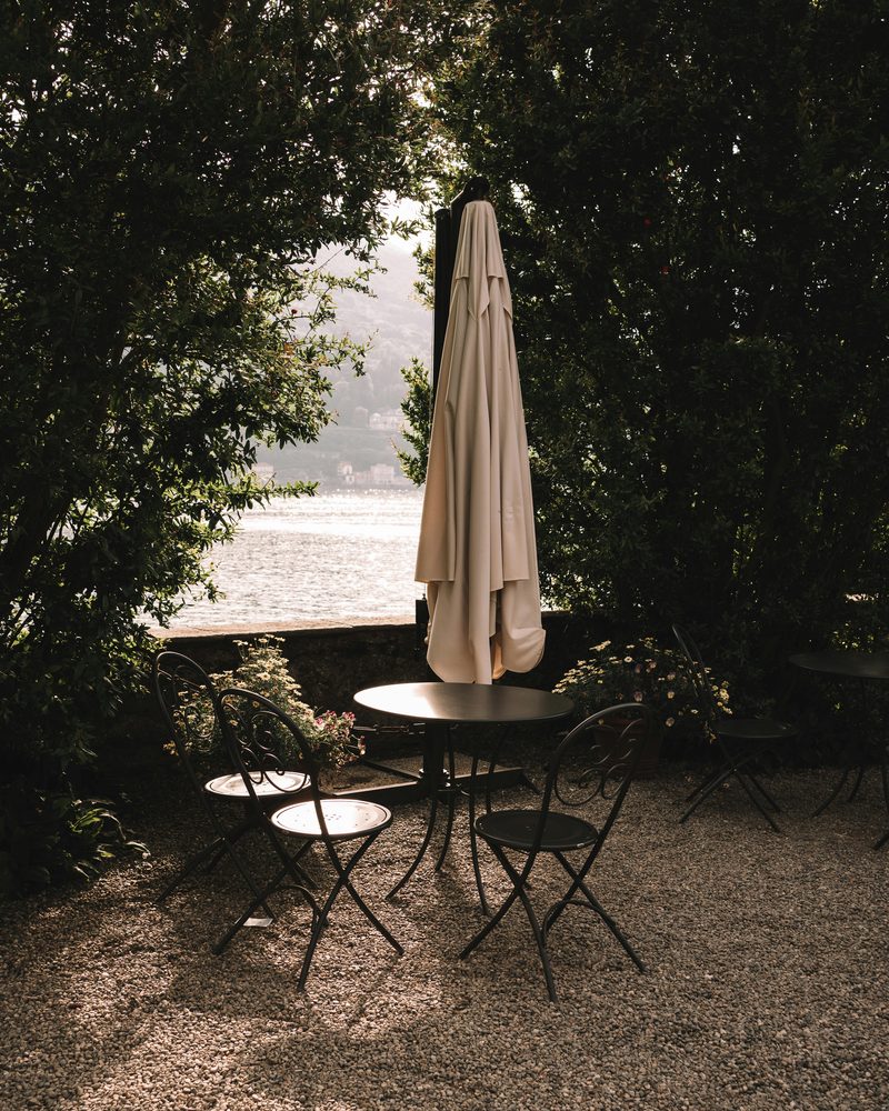 A bistro table and chairs under a parasol