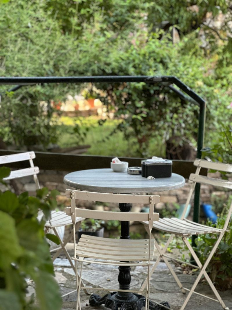 A bistro table surrounded by dense garden planting