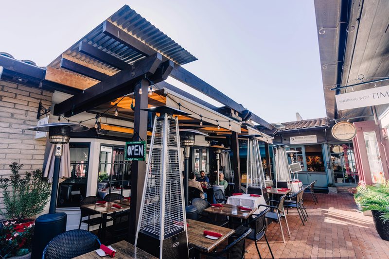 A shaded outdoor seating area with a pergola and planting