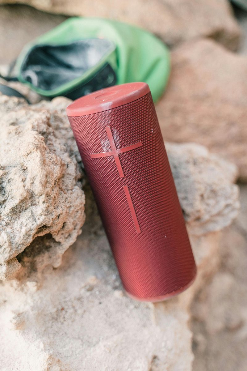 A portable Bluetooth speaker on a garden wall