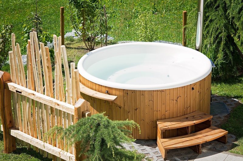 A wooden barrel hot tub in a garden