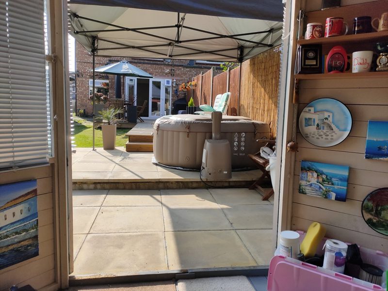 A gazebo set up over a hot tub in a garden